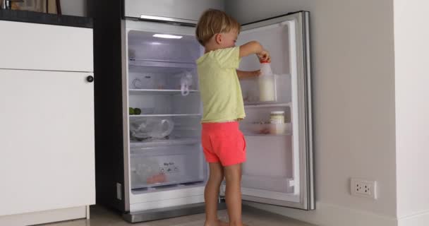 Małe dziecko z pokrywką lodówka mleko — Wideo stockowe