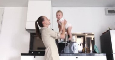 Mutlu anne bebek beyaz mutfak arka plan atar