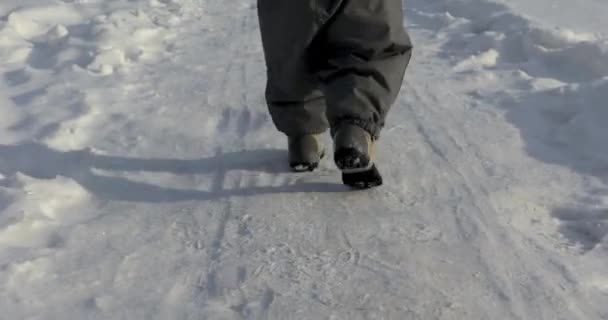 Маленькие ноги ребенок бежит снежная дорога — стоковое видео