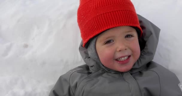 Mignon bébé blanc fond de neige souriant — Video