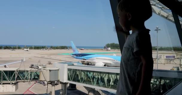 Boy looks at the passengers of plane and waves them — Stock Video