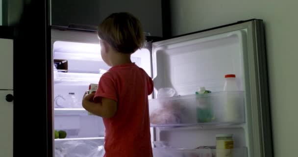 Child takes refrigerator box juice straw — Stock Video