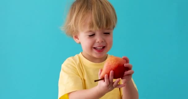 Dulce niño sonríe con pera roja — Vídeos de Stock