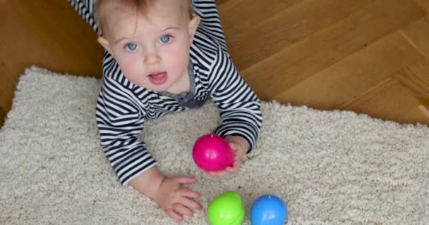 Kwijlende baby spelen met kleurrijke speelgoed — Stockvideo