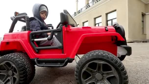 Хлопчик їде на іграшковій машині — стокове відео