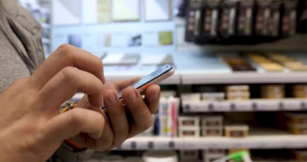 Hombre stand uso teléfono hold jamón en ferretería — Vídeos de Stock