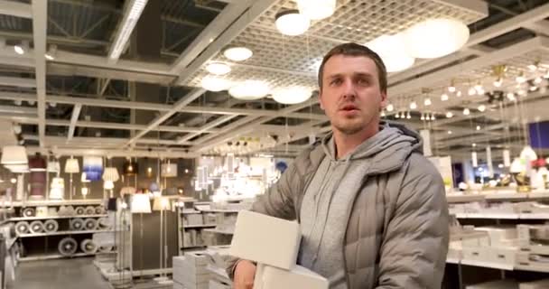 Enda man håller en glödlampa i hushålls butiken — Stockvideo