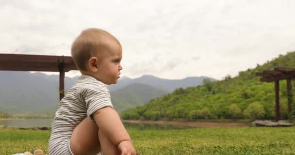 Bebê sentado na grama — Vídeo de Stock