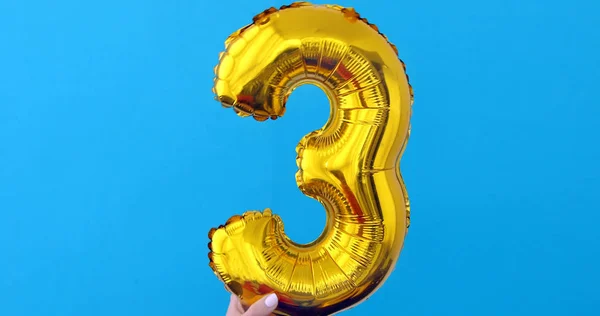 Gold foil number 3 celebration balloon on a blue — Stock Photo, Image