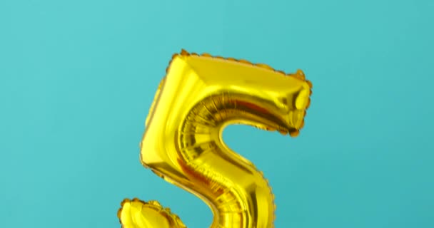 Goud folie nummer 5 viering ballon op een blauw — Stockvideo
