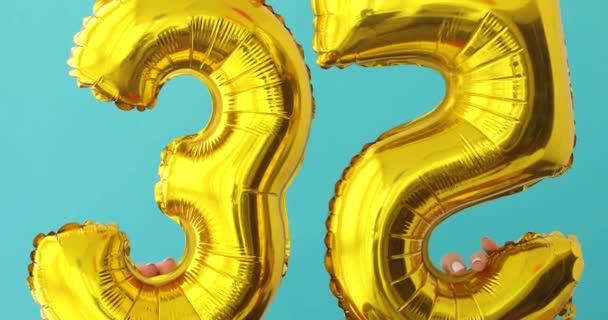 Χρυσό αλουμινόχαρτο αριθμός 35 μπαλόνι εορτασμού σε ένα μπλε — Αρχείο Βίντεο