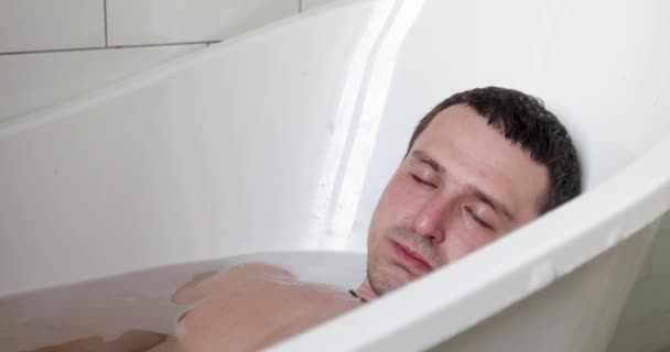 Mladý pohledný muž relaxující ve vaně — Stock video