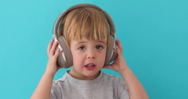 Baby neemt uit zijn hoofdtelefoon — Stockvideo