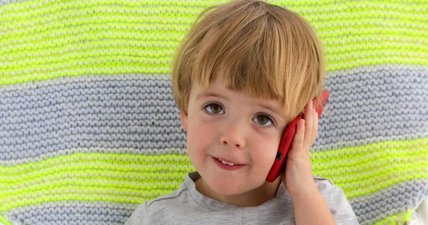 Petit enfant souriant tenant la main du garçon téléphone portable — Photo