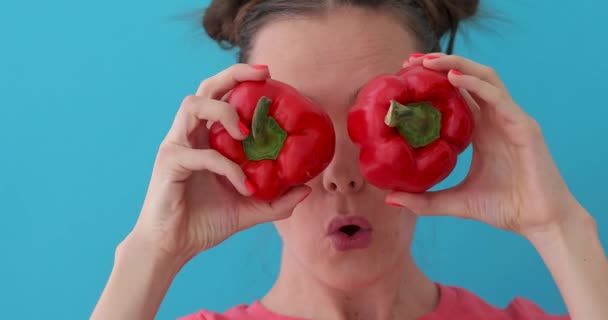 Kvinna håller peppar i händerna som ögon — Stockvideo