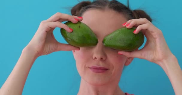 Fröhliche Frau macht Avocadoaugen — Stockvideo