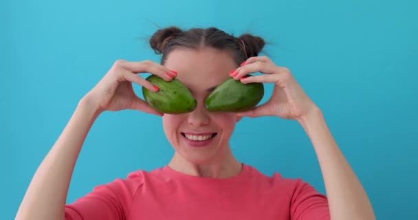 Fröhliche Frau macht Avocadoaugen — Stockvideo