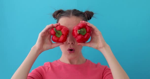 Woman wonders holds pepper in her hands like eyes — Stock Video