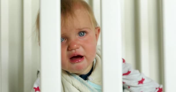 Плачущий ребенок в детской кроватке дома — стоковое видео