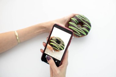 Akıllı telefonlu donut fotoğraflayan kadın. 