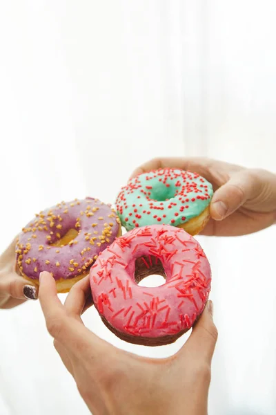 Mãos com deliciosos donuts — Fotografia de Stock