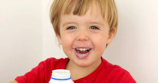 Joyful child drinking yogurt — Stock Photo, Image