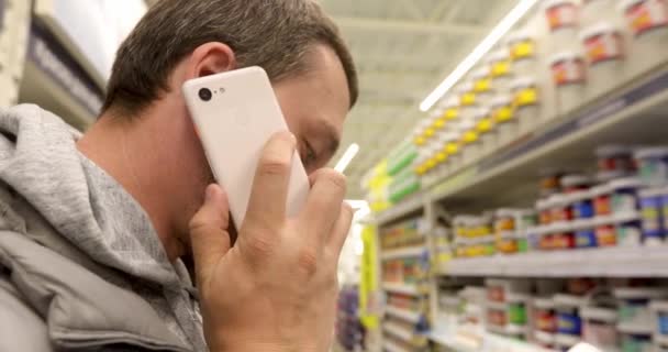 Homem falando no telefone na loja — Vídeo de Stock