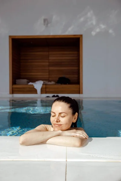 Jeune femme jouissant de repos dans la piscine — Photo