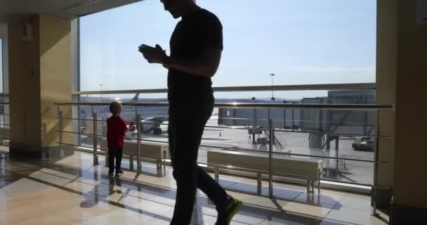 Padre anónimo usando smartphone mientras niño mirando aviones — Vídeos de Stock