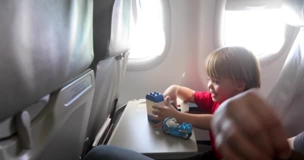 Alegre niño jugando con juguetes durante el vuelo — Vídeos de Stock