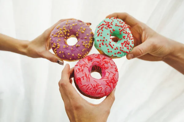 Mãos com deliciosos donuts — Fotografia de Stock