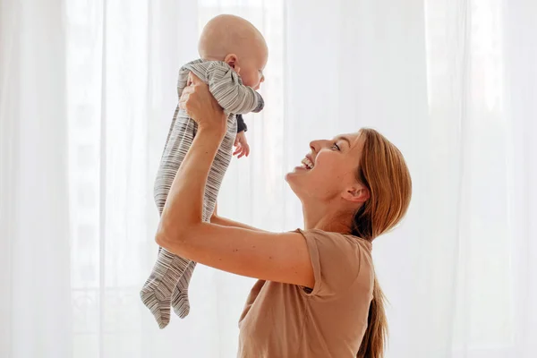 Mutlu aile annesi yeni doğmuş bebekle oynuyor. — Stok fotoğraf