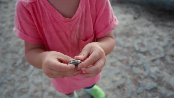 Çocuğun elinde demir yuvarlak sikke — Stok video