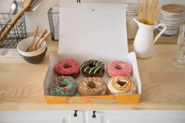 Caixa com donuts na mesa — Fotografia de Stock
