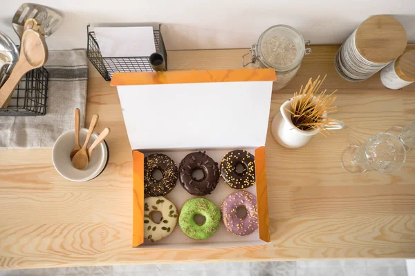 Box with doughnuts on table