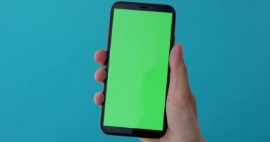 Kadın el greeen ekranlı bir akıllı telefon tutar