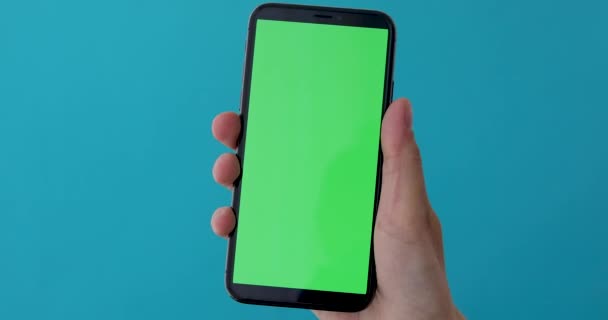 Woman hand holds a smartphone with greeen screen — Stock Video