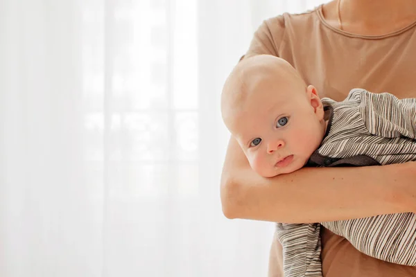 Curious cheeky baby on hands of mother — Stock Photo, Image