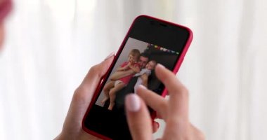 Aile resmini gösteren akıllı telefonlu kadın eli