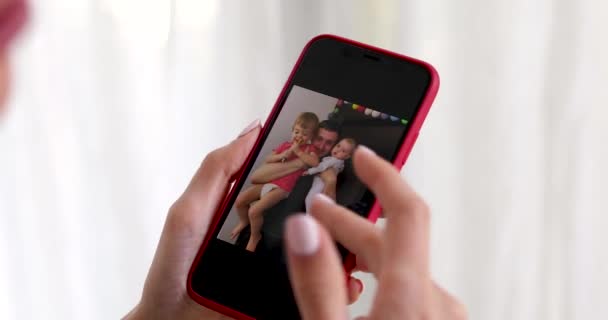 Женщина рука со смартфоном показывает семейное фото — стоковое видео