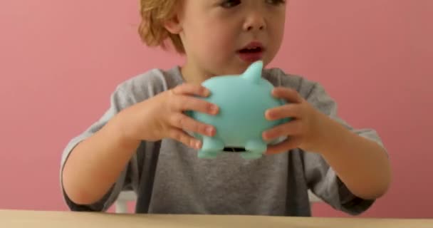 男の子は彼の貯金箱を振る — ストック動画