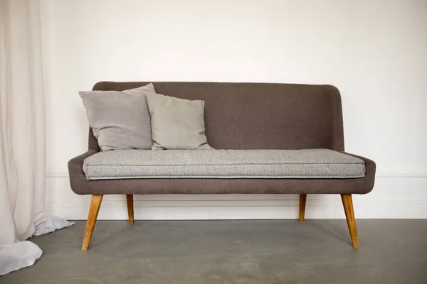 Απλός καφέ και γκρι καναπές με ξύλινα πόδια — Φωτογραφία Αρχείου