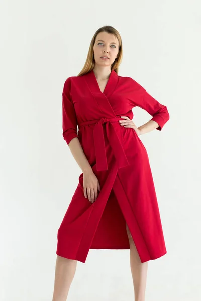 Привлекательная молодая женщина в красном платье с рукой на талии — стоковое фото