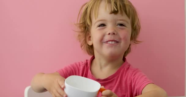 Criança feliz bebe leite de um copo — Vídeo de Stock