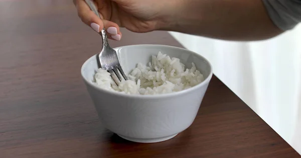Closeup of woman eating rice from bowl