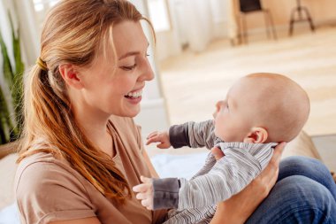 Neşeli anne evde bebek tutarak