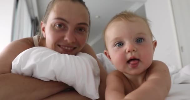 Sonriente mamá con el niño en la cama — Vídeo de stock