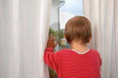 Bebek pencereden dışarı bakıyor