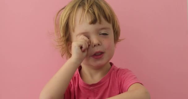 Lindo niño frotando ojo con la mano regordeta — Vídeo de stock