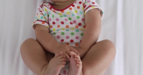 Crop bebê deitado em tecido branco — Vídeo de Stock